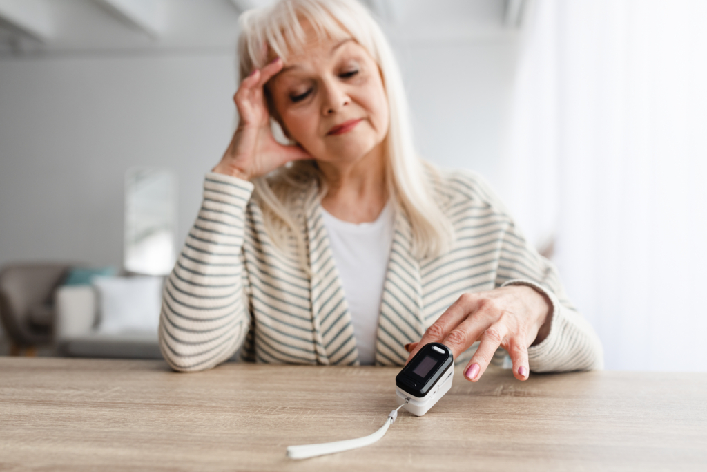 senior woman using oximeter at home healthcare