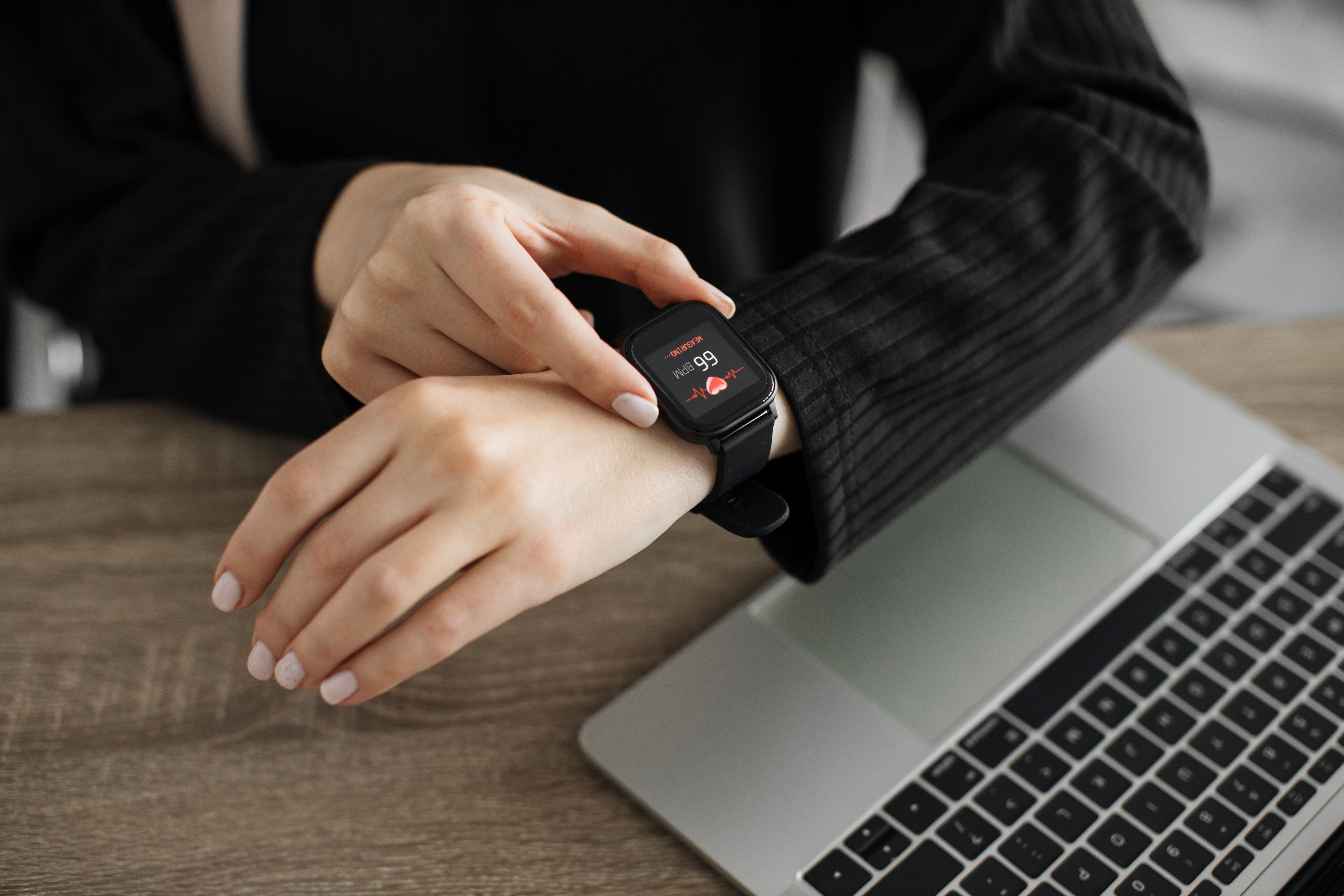 Cropped view of muslim female hands, putting finger on smartwatch, measuring heartbeat rate